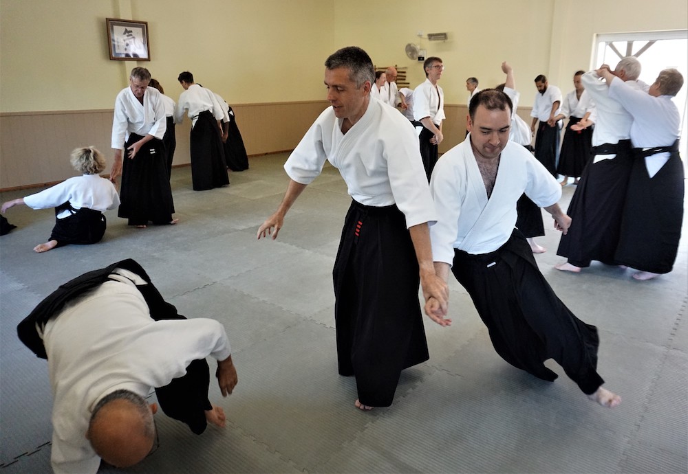 Three people training together at the headquarters dojo