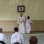 Students watch as the teacher demonstrates a shihonage.