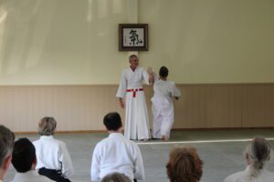 Students watch as the teacher demonstrates a shihonage.