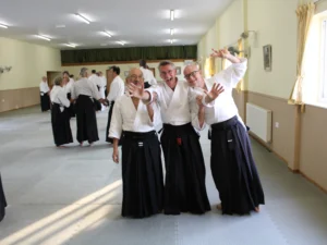 Three students, aware of the camera, waving and laughing.